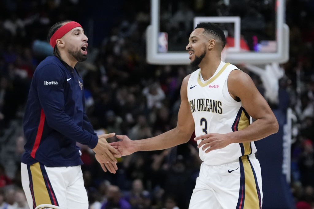 New Orleans Pelicans guard CJ McCollum (3) is greeted by guard Jose Alvarado after a scoring run in the first half of an NBA basketball game against the Los Angeles Lakers in New Orleans, Sunday, Dec. 31, 2023. 