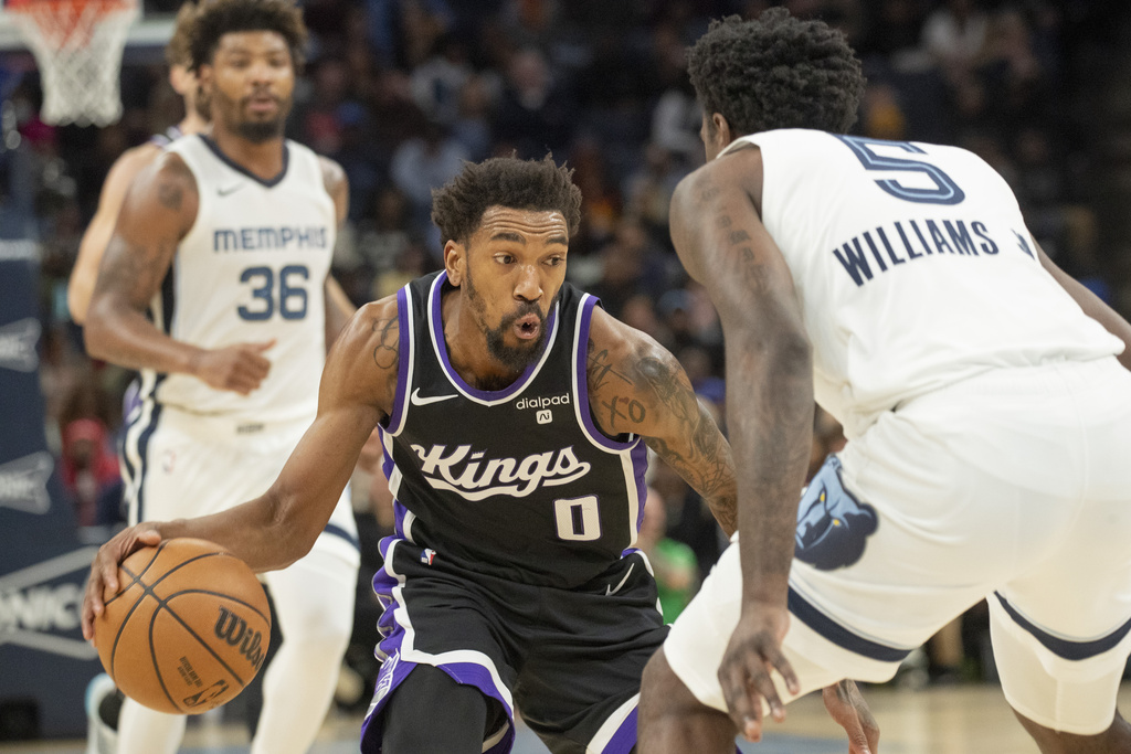 Sacramento Kings guard Malik Monk (0) dribbles the ball defended by Memphis Grizzlies guard Vince Williams Jr. in the second half of an NBA basketball game, Sunday, Dec. 31, 2023, in Memphis, Tennessee. 