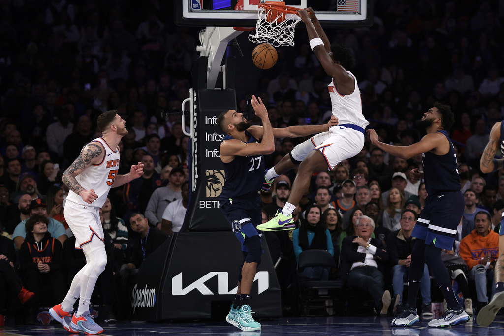 New York Knicks forward OG Anunoby dunks the ball over Minnesota Timberwolves center Rudy Gobert (27) during the first half of an NBA basketball game Monday, Jan. 1, 2024, in New York. 