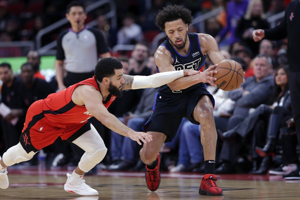 Houston Rockets guard Fred VanVleet, left, lunges for a loose ball as Detroit Pistons guard Cade Cunningham, right, makes the recovery during the first half of an NBA basketball game, Monday, Jan. 1, 2024, in Houston