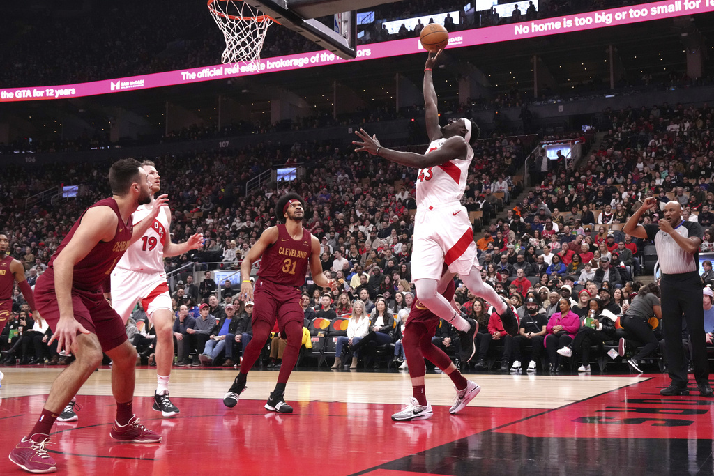 Toronto Raptors' Pascal Siakam shoots as Cleveland Cavaliers guard Max Strus, Raptors center Jakob Poeltl (19) and Cavaliers centre Jarrett Allen look on during the first half of an NBA basketball game in Toronto, Monday, Jan. 1, 2024.