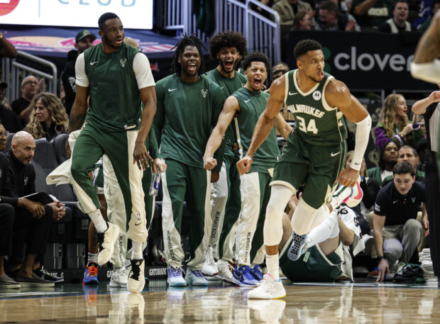 The Milwaukee Bucks bench reacts as Giannis Antetokounmpo (34) dunks against the Indiana Pacers during the first half of an NBA basketball game, Monday, Jan. 1, 2024, in Milwaukee