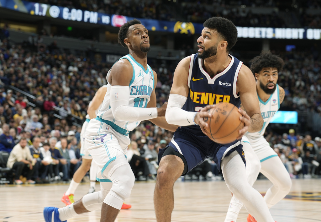Denver Nuggets guard Jamal Murray, right, goes up for a basket as Charlotte Hornets guard Ish Smith defends in the first half of an NBA basketball game, Monday, Jan. 1, 2024, in Denver.