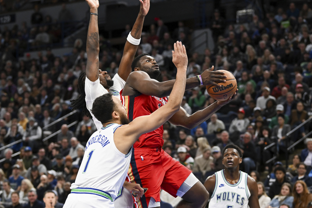 New Orleans Pelicans forward Zion Williamson, right, drives to the basket past Minnesota Timberwolves forward Kyle Anderson (1) and center Naz Reid during the first half of an NBA basketball game Wednesday, Jan. 3, 2024, in Minneapolis.