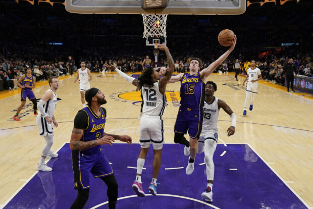 Los Angeles Lakers guard Austin Reaves (15) shoots against Memphis Grizzlies guard Ja Morant (12) during the first half of an NBA basketball game in Los Angeles, Friday, Jan. 5, 2024.
