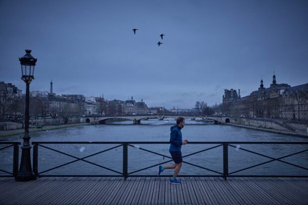 GAMES VENUE A man runs on the Pont des Arts bridge over the Seine river, in Paris, on Feb. 21. The scenic but often polluted river will be the venue of open water swimming events during this year’s Olympic Games. —AFP