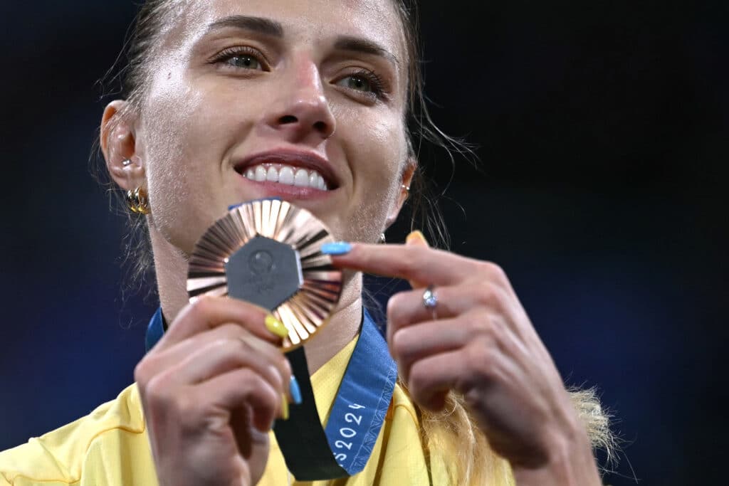 Bronze medallist Ukraine's Olga Kharlan celebrates on the podium during the medal ceremony for the women's sabre individual competition during the Paris 2024 Olympic Games at the Grand Palais in Paris, on July 29, 2024. 