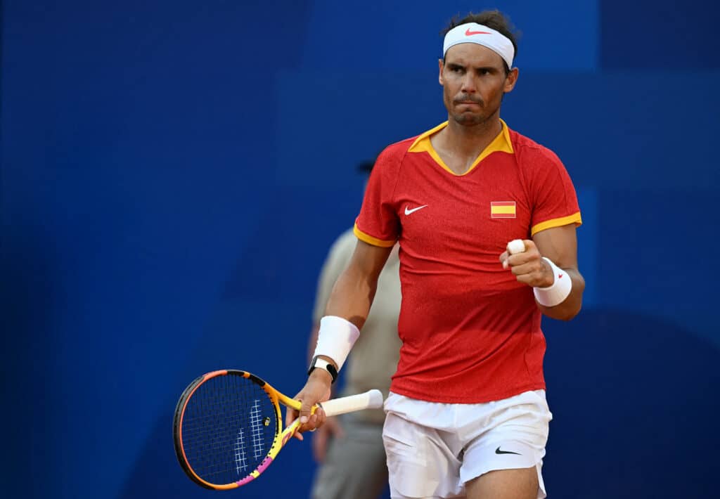 O espanhol Rafael Nadal joga com o espanhol Carlos Alcaraz e reage ao jogar contra o holandês Tallon Griekspoor e o holandês Wesley Koolhof durante a partida de duplas da segunda rodada de tênis na quadra Suzanne-Lenglen.