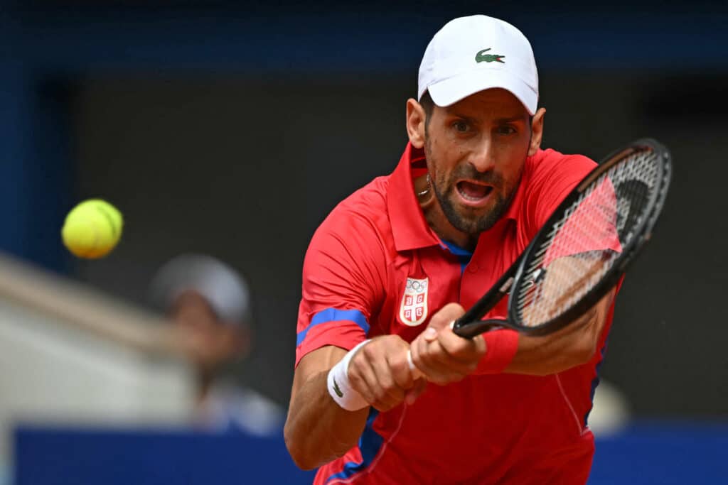 El serbio Novak Djokovic regresa al alemán Dominik Koepfer durante su partido de tenis de tercera ronda individual masculino en la cancha Philippe-Chatrier en el Estadio Roland-Garros durante los Juegos Olímpicos de París 2024, en París el 31 de julio de 2024.