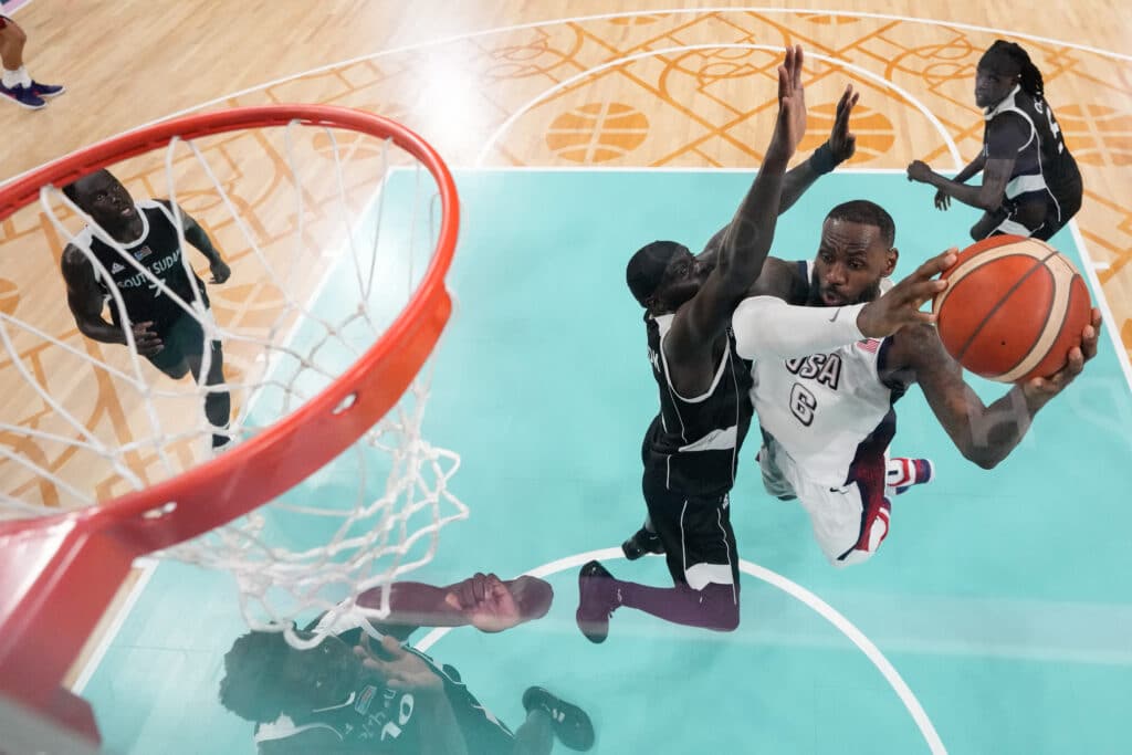 South Sudan's #11 Marial Shayok (L) defends against USA's #06 LeBron James in the men's preliminary round group C basketball match between USA and South Sudan during the Paris 2024 Olympic Games at the Pierre-Mauroy stadium in Villeneuve-d'Ascq, northern France, on July 31, 2024. 