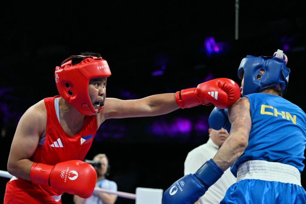 Philippines' Nesthy Petecio and China's Xu Zichun (Blue) compete in the women's 57kg quarter-final boxing match during the Paris 2024 Olympic Games at the North Paris Arena, in Villepinte on August 4, 2024. (Photo by MOHD RASFAN / AFP)