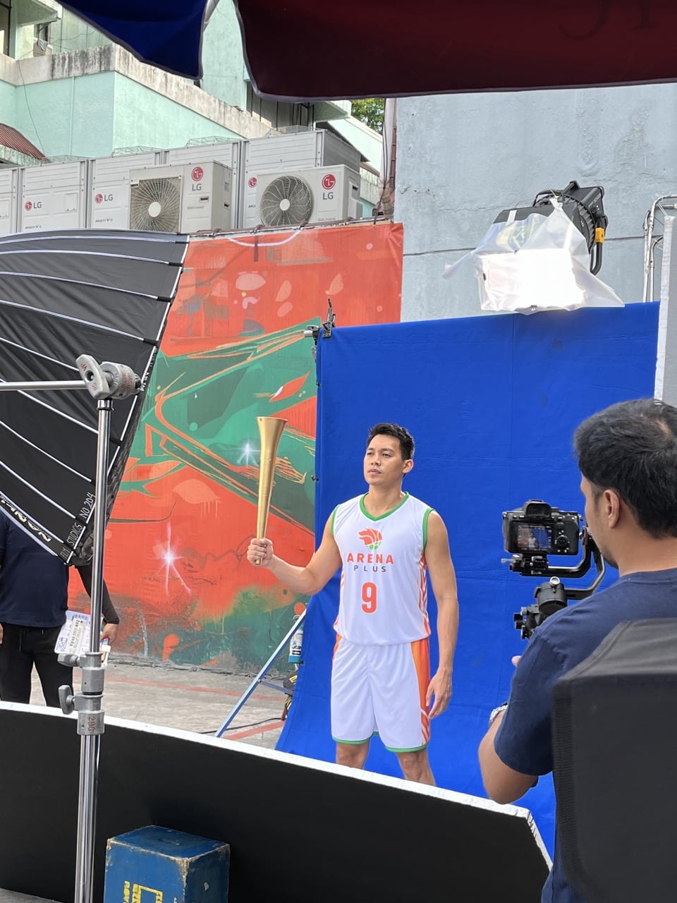 Behind the scenes shot of Scottie Thompson carrying the torch.