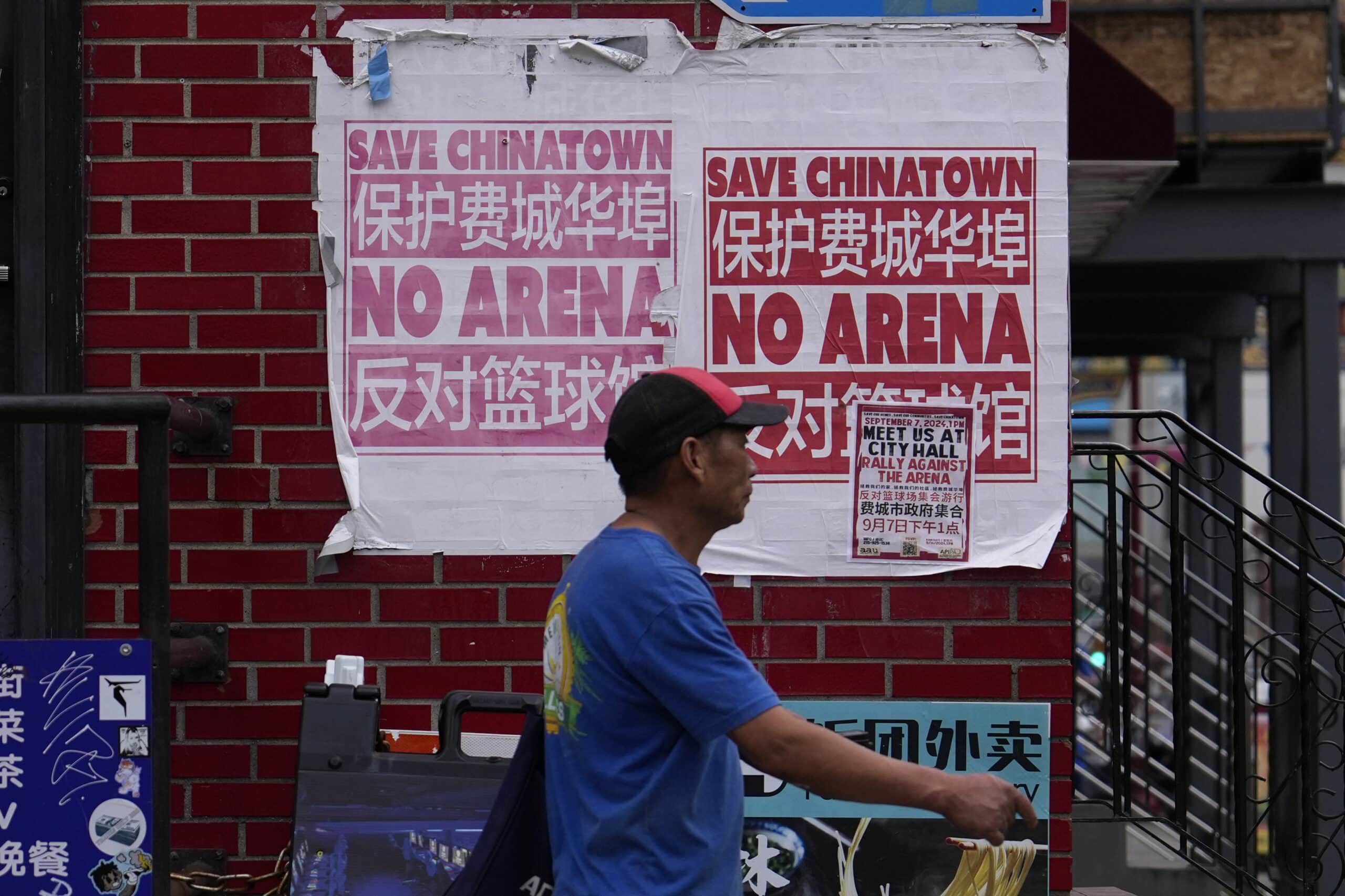 Un hombre camina por el barrio de Chinatown de Filadelfia 76ers New Arena Mayor Basketball