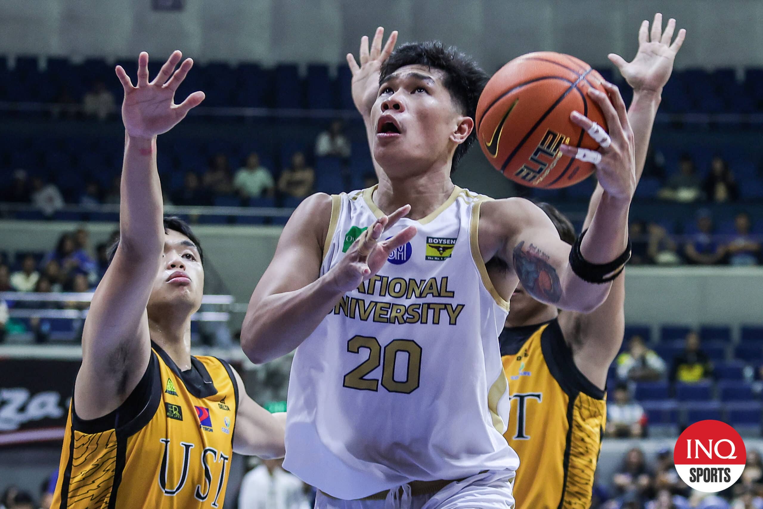 NU Bulldogs' Jake Figueroa against UST defenders during a UAAP Season 87 men's basketball tournament.