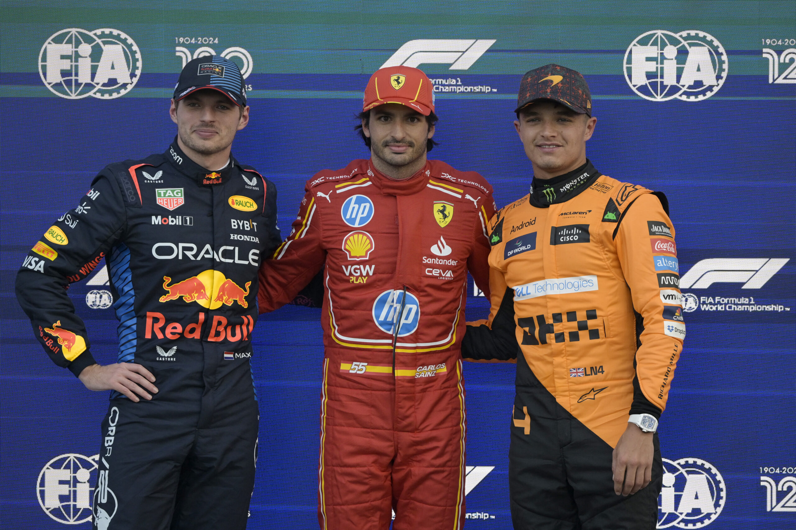 Pole position winner Ferrari's Spanish driver Carlos Sainz (C) poses for a picture next to Red Bull Racing's Dutch driver Max Verstappen (L) and McLaren's British driver Lando Norris F1