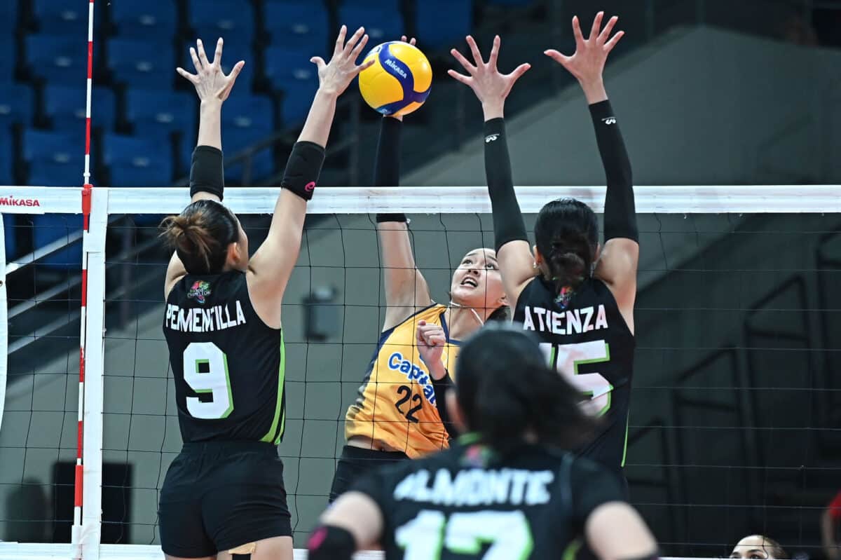 Leila Cruz (center) smartly drills in a kill between two Nxled blockers. 