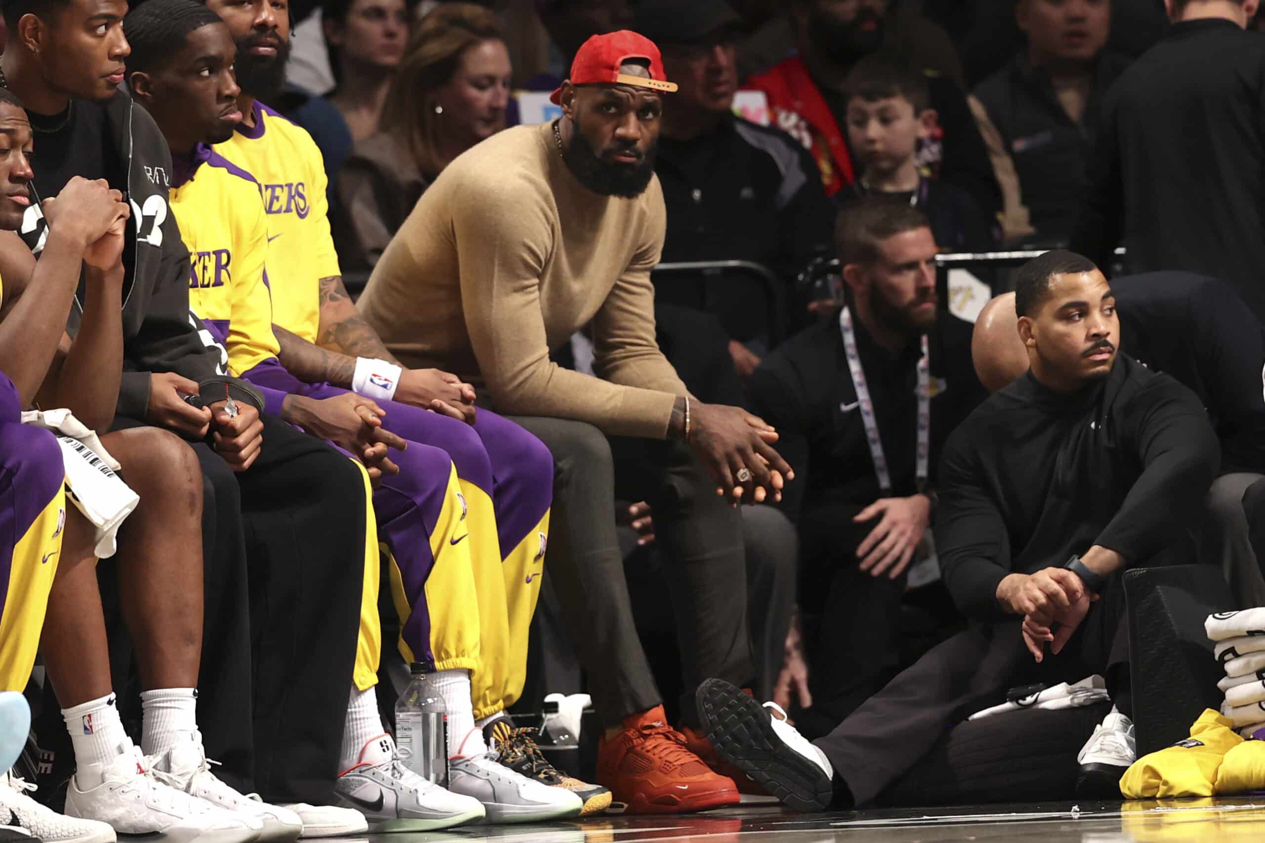 Los Angeles Lakers' LeBron James, center, sits on the bench during the second half of an NBA basketball game against the Brooklyn Nets, Monday, March 10, 2025, in New York.