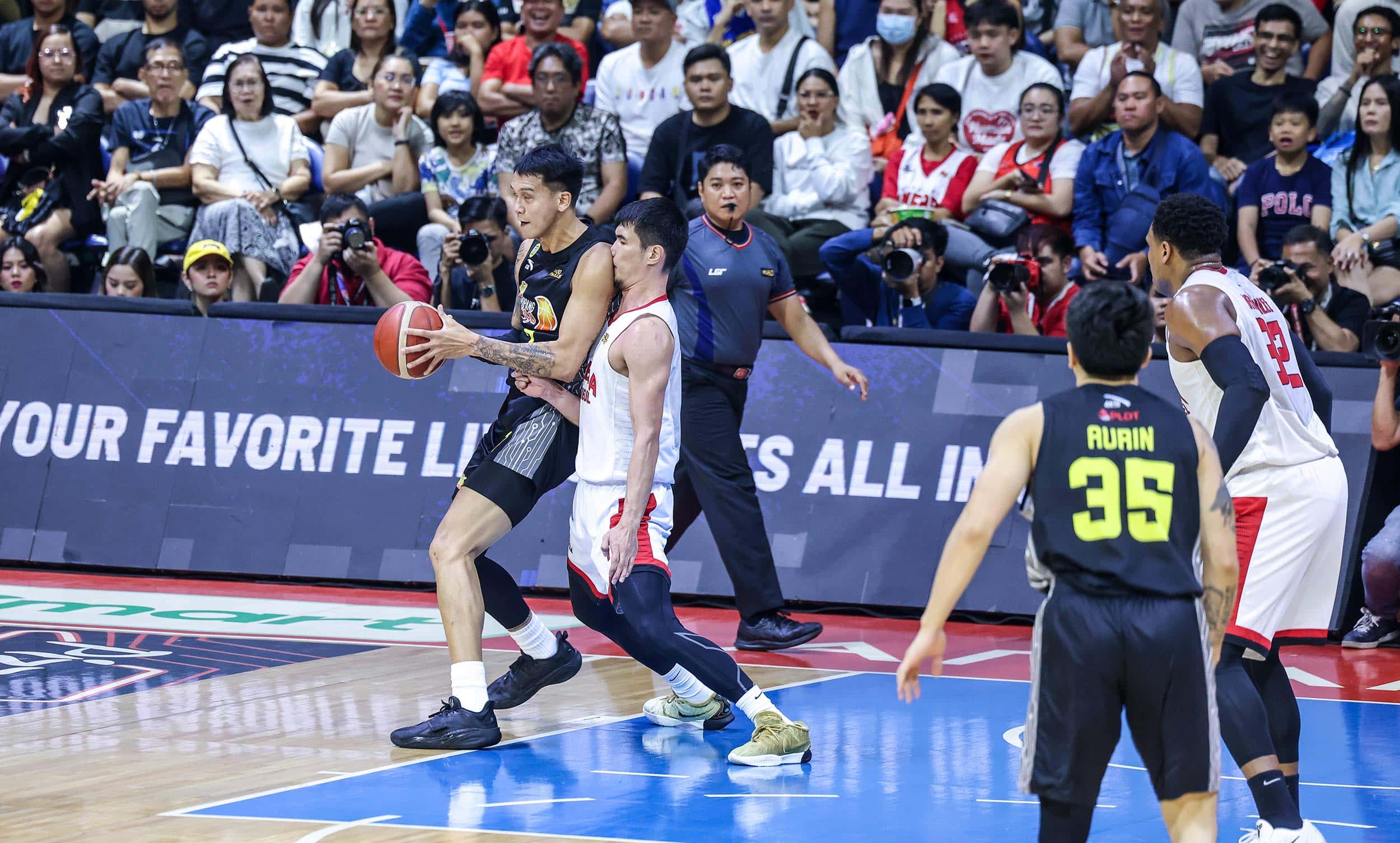 TNT center Poy Erram against Barangay Ginebra's Troy Rosario during Game 5 of the PBA Commissioner's Cup Finals.