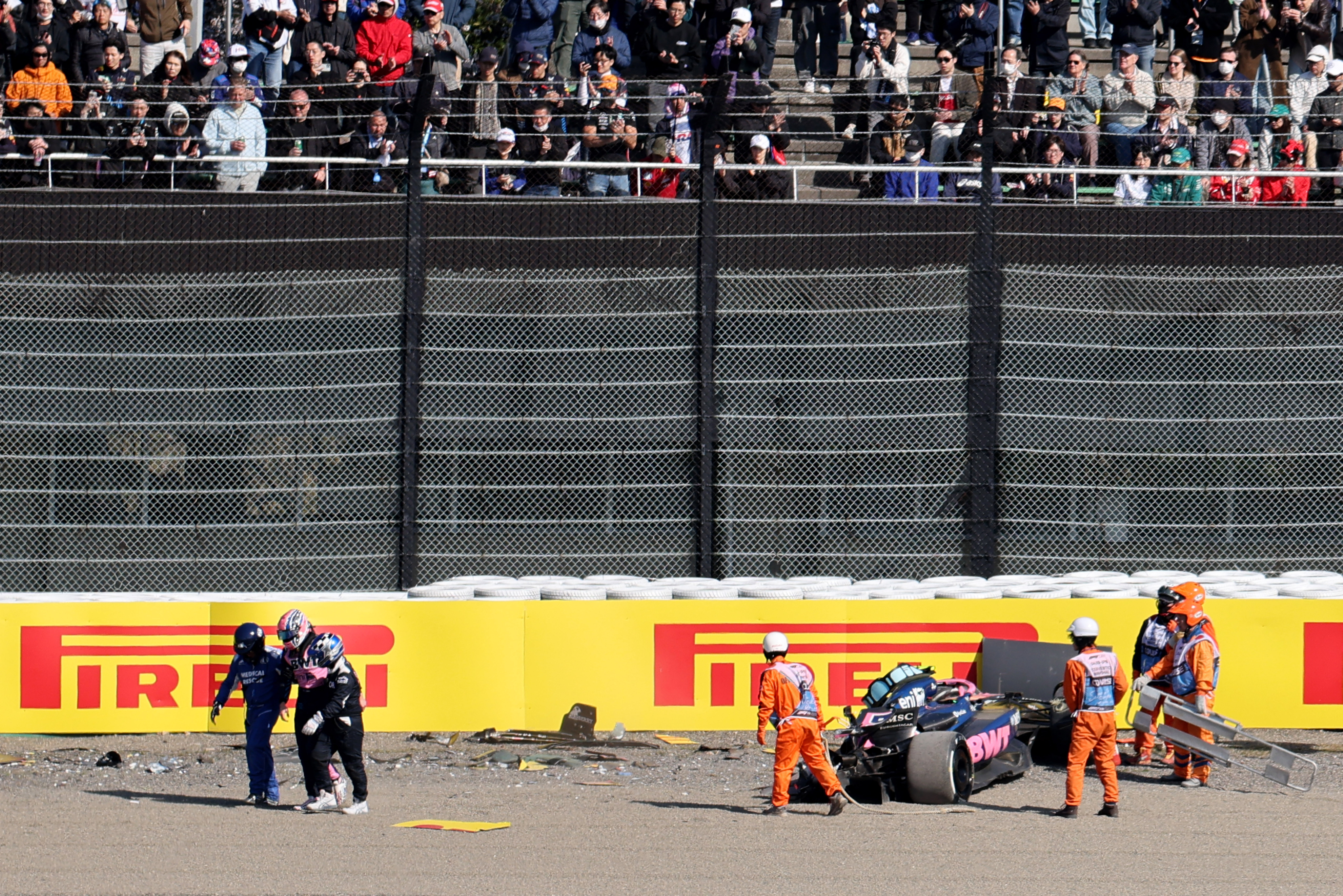 Formula One F1 - Japanese Grand Prix - Suzuka Circuit, Suzuka, Japan - April 4, 2025 Alpine's Jack Doohan walks away with a medical team as marshals attend his car after the crashing during practice
